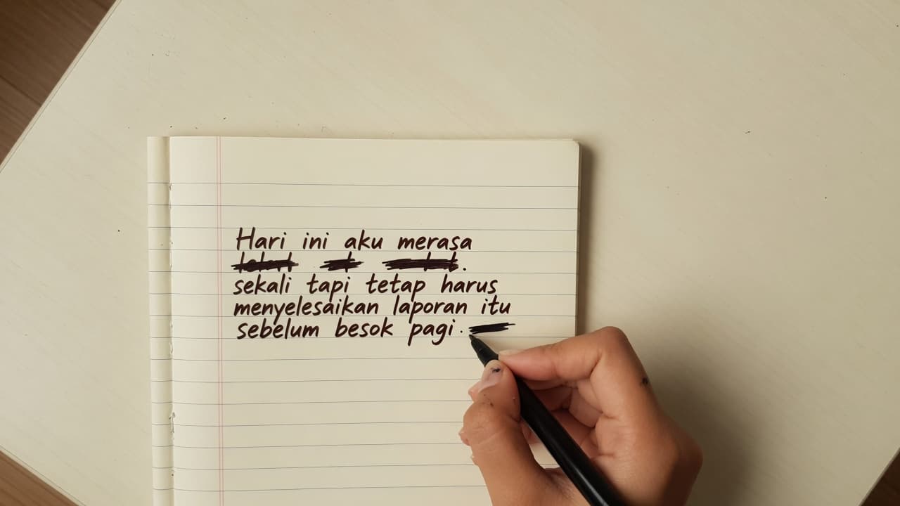 Tangan menulis satu kalimat ide di buku catatan